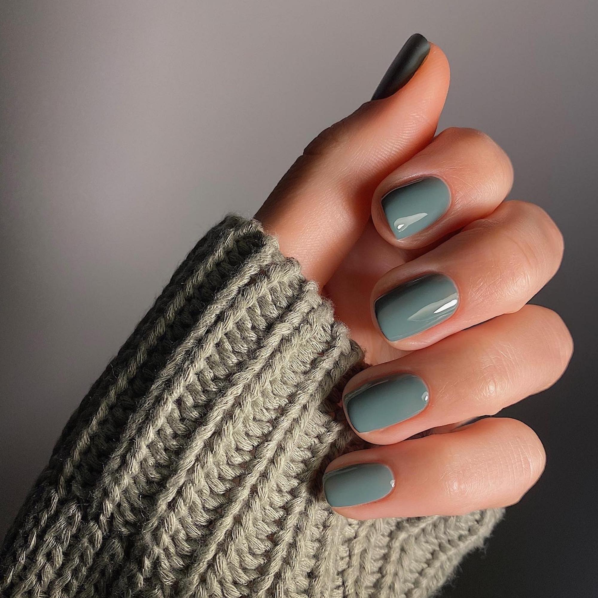 Freshly manicured nails in moss green polish from A Weathered Penny, modelled with a knit jumper sleeve